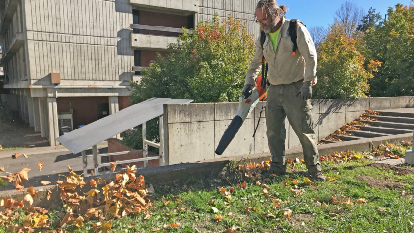 Kyle Riggs uses a battery-powered leaf blower on the SOU campus